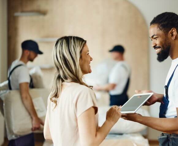 mover-using-touchpad-with-his-customer-in-the-apartment